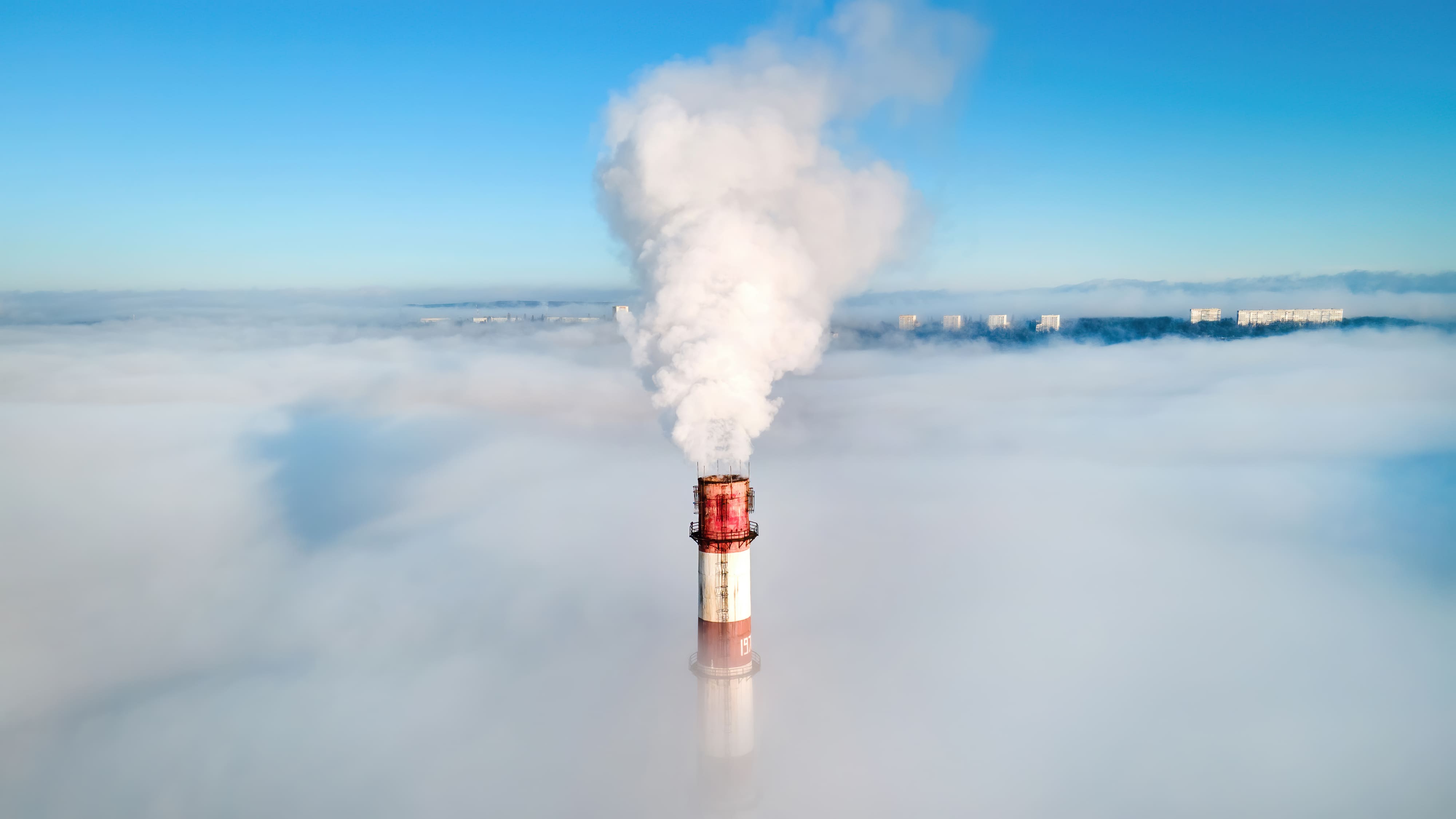 Chimney emitting smoke into the environment, representing the need for Direct Air Capture (DAC) technologies to reduce CO₂ emissions